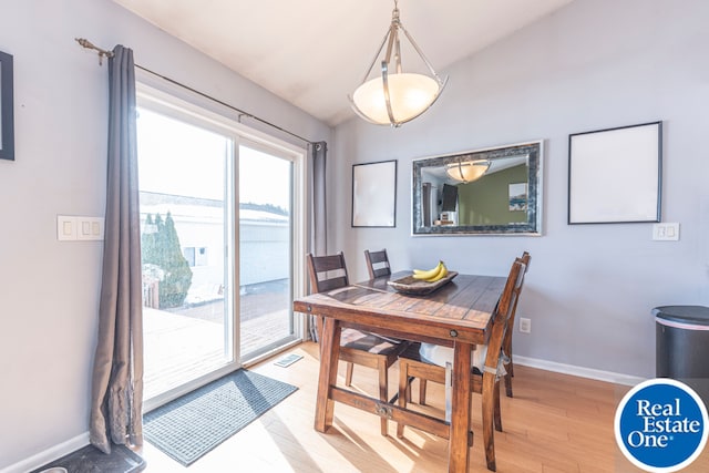 dining room with visible vents, vaulted ceiling, light wood-style flooring, and baseboards