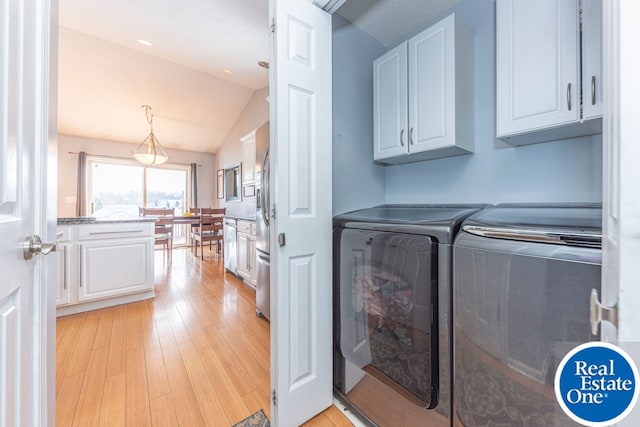 washroom featuring cabinet space, washer and clothes dryer, and light wood finished floors