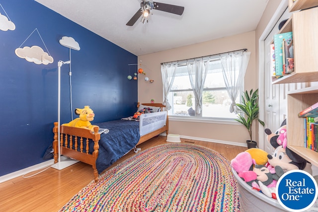 bedroom with lofted ceiling, ceiling fan, baseboards, and wood finished floors