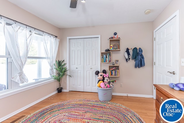 bedroom with a closet, visible vents, a ceiling fan, wood finished floors, and baseboards