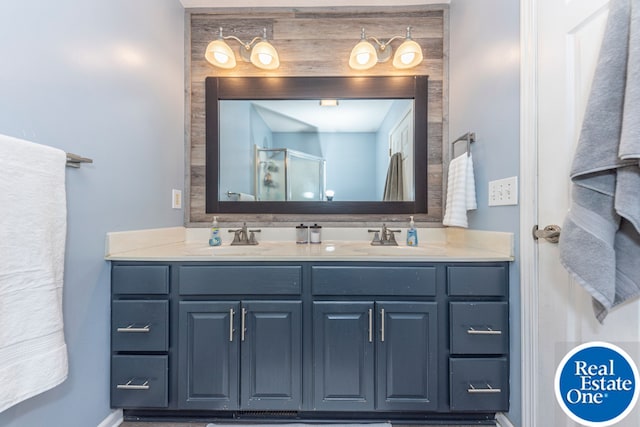 bathroom with double vanity, a sink, and a shower stall