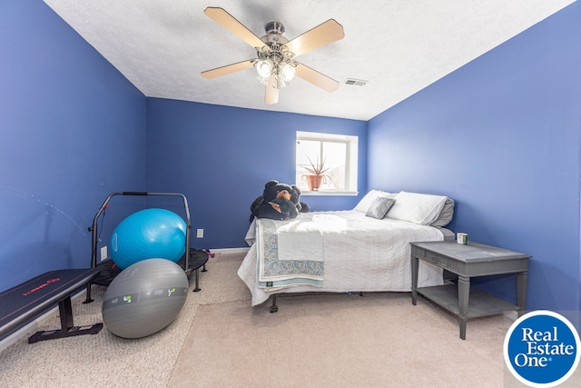 carpeted bedroom with a ceiling fan, visible vents, and a textured ceiling