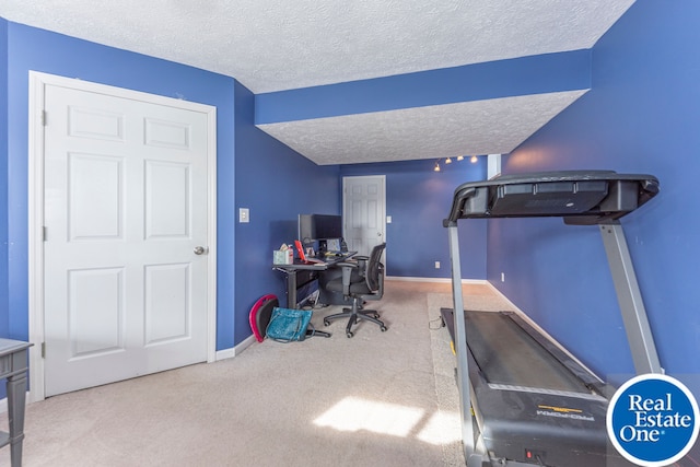 carpeted office space featuring a textured ceiling and baseboards