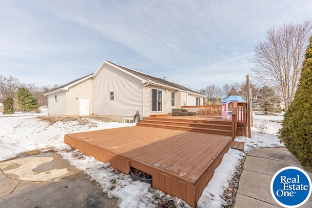 snow covered back of property featuring a deck