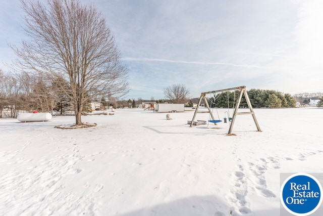 yard covered in snow with playground community