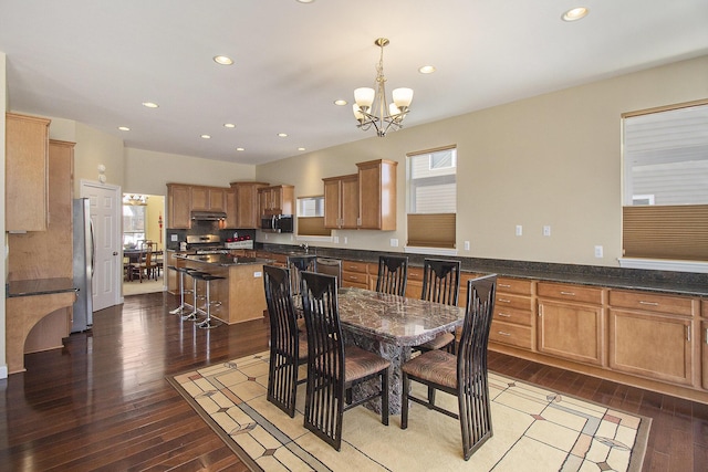 dining space featuring a chandelier, dark wood-style flooring, recessed lighting, and a healthy amount of sunlight