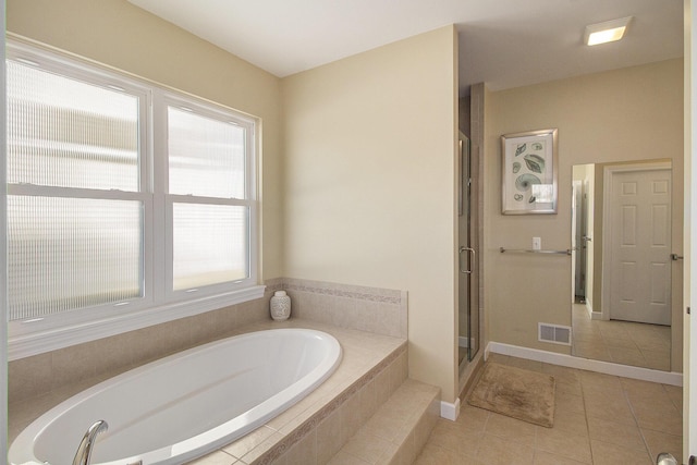 bathroom with tile patterned floors, visible vents, a stall shower, baseboards, and a bath