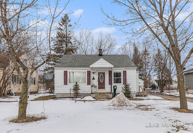 bungalow-style house with a shingled roof and a chimney