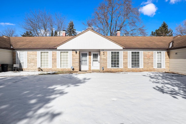 view of front of home featuring stone siding and a chimney