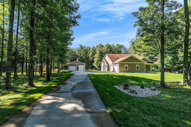 view of front of home featuring an outbuilding, a detached garage, and a front lawn