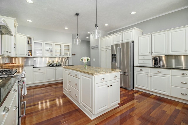 kitchen featuring high end appliances, a center island, white cabinetry, and decorative light fixtures