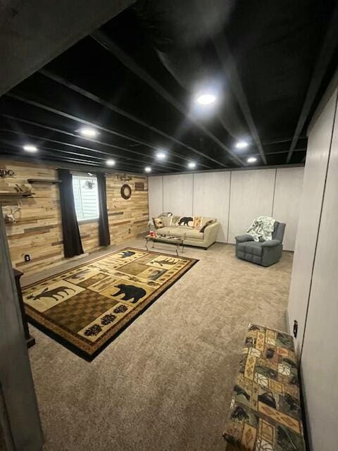 basement featuring carpet floors and wooden walls