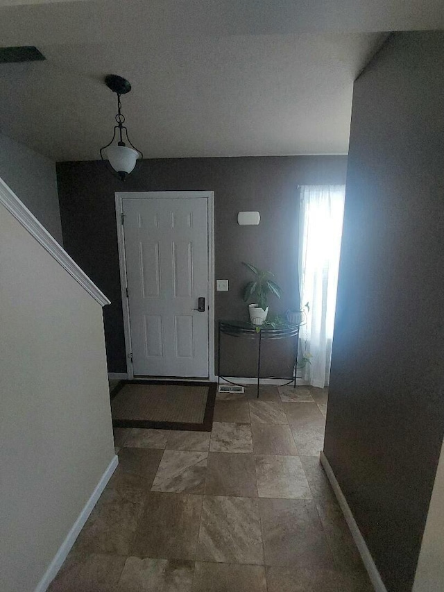 foyer entrance featuring visible vents and baseboards