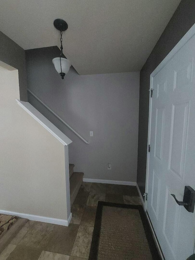 foyer entrance with baseboards and stairway