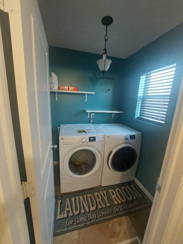 clothes washing area featuring laundry area, tile patterned flooring, and washing machine and dryer