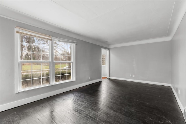 spare room with crown molding, dark wood-type flooring, and baseboards