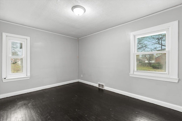 empty room featuring a healthy amount of sunlight, visible vents, and baseboards