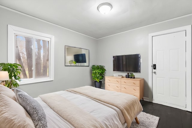 bedroom with dark wood-style floors and ornamental molding