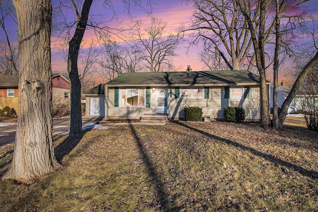 single story home featuring an outbuilding and a front yard