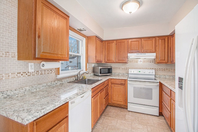 kitchen featuring visible vents, backsplash, a sink, white appliances, and under cabinet range hood