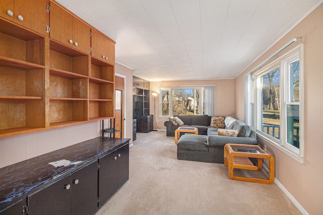 living area featuring light carpet and baseboards