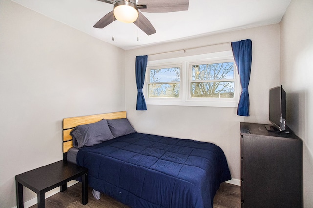 bedroom with a ceiling fan, dark wood-style flooring, and baseboards