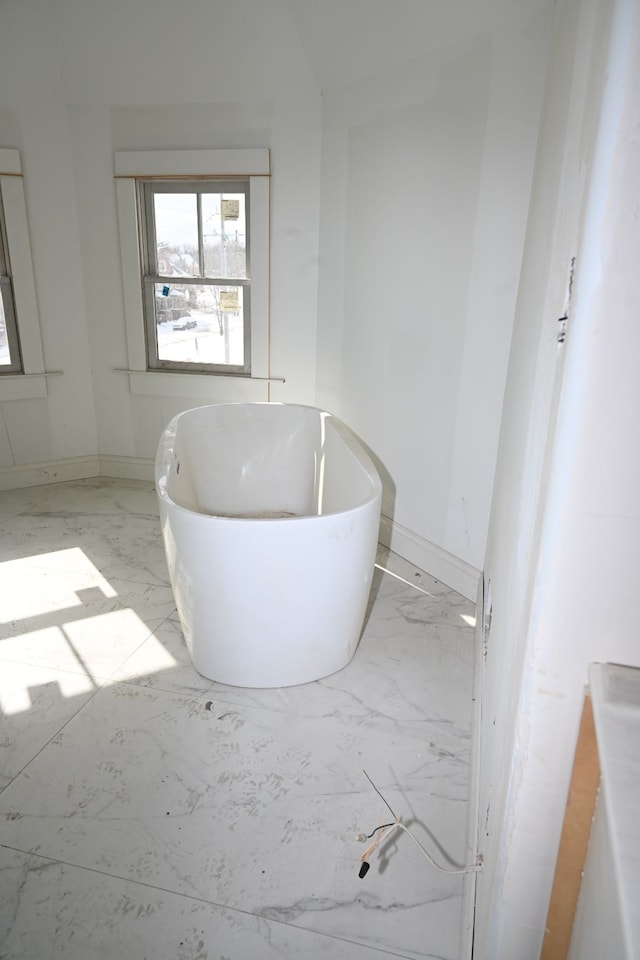 bathroom featuring marble finish floor and baseboards