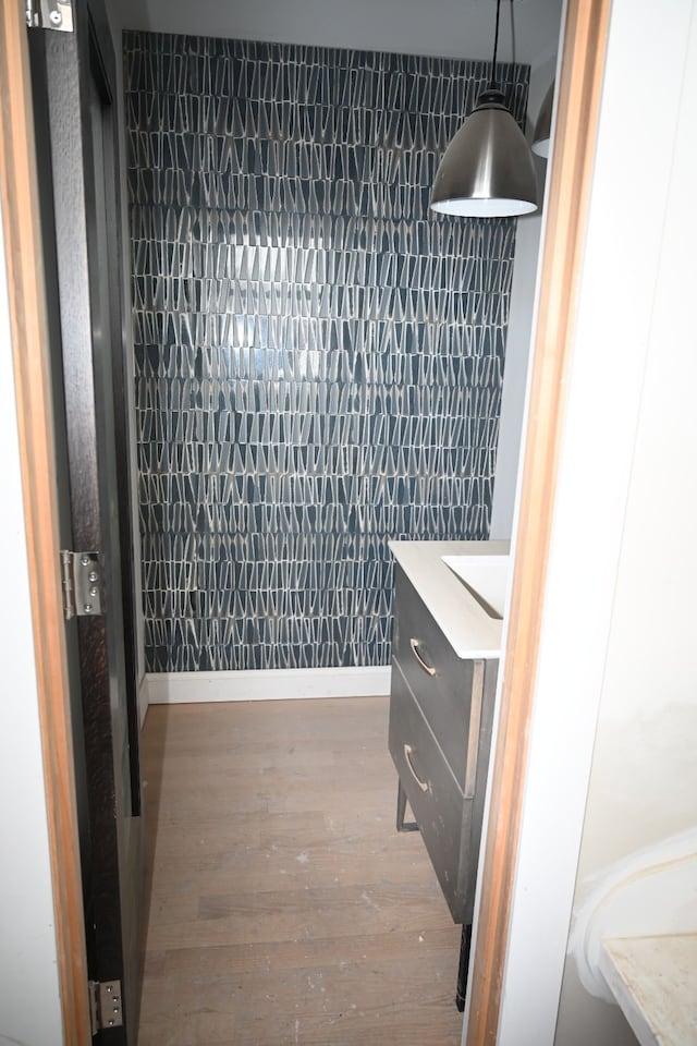 interior space with vanity, baseboards, and wood finished floors