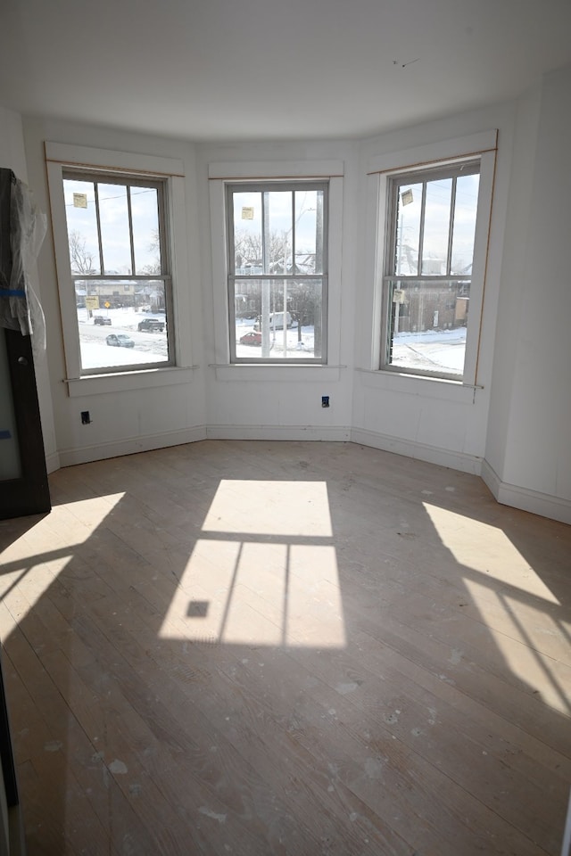 unfurnished room with baseboards and light wood finished floors