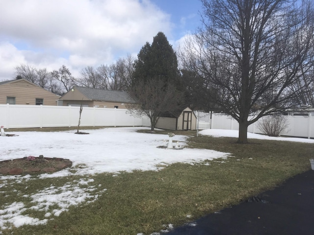 yard layered in snow with a garage, a shed, an outdoor structure, and a fenced backyard