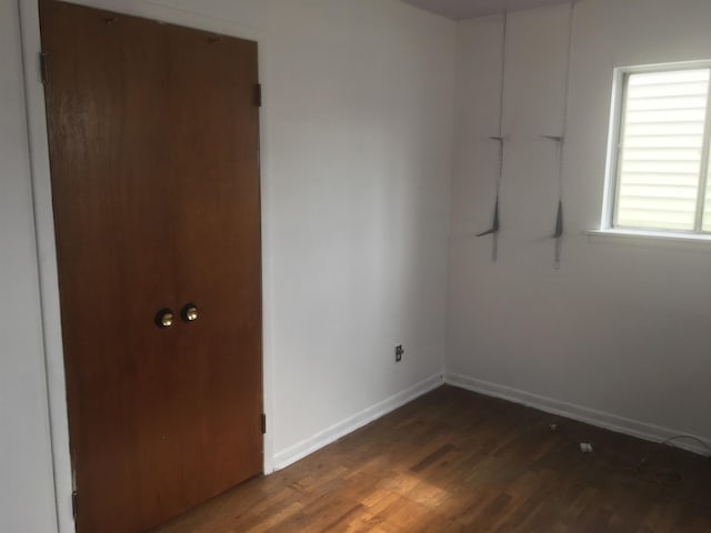 unfurnished room with baseboards and wood finished floors