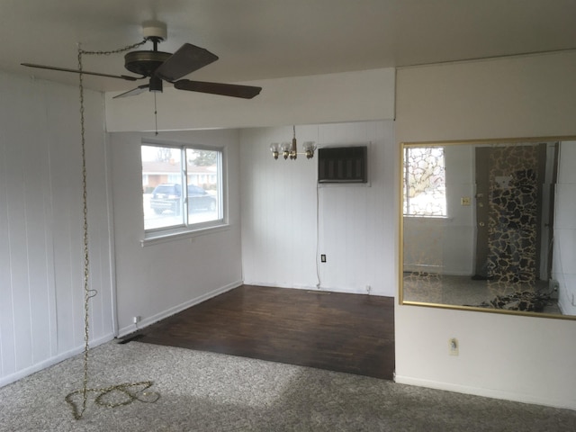 carpeted spare room with ceiling fan, wood finished floors, a wealth of natural light, and a wall mounted AC