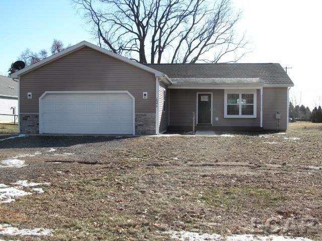 single story home with driveway, stone siding, and a garage