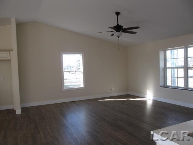 interior space featuring dark wood-style floors, lofted ceiling, ceiling fan, and baseboards