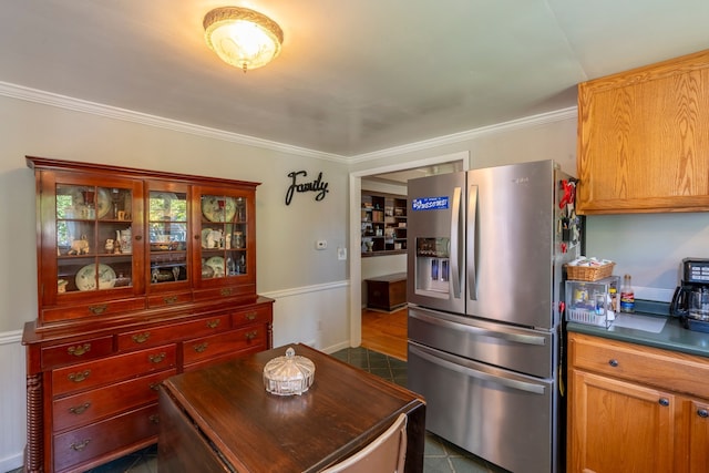 kitchen with dark countertops, stainless steel fridge, and ornamental molding