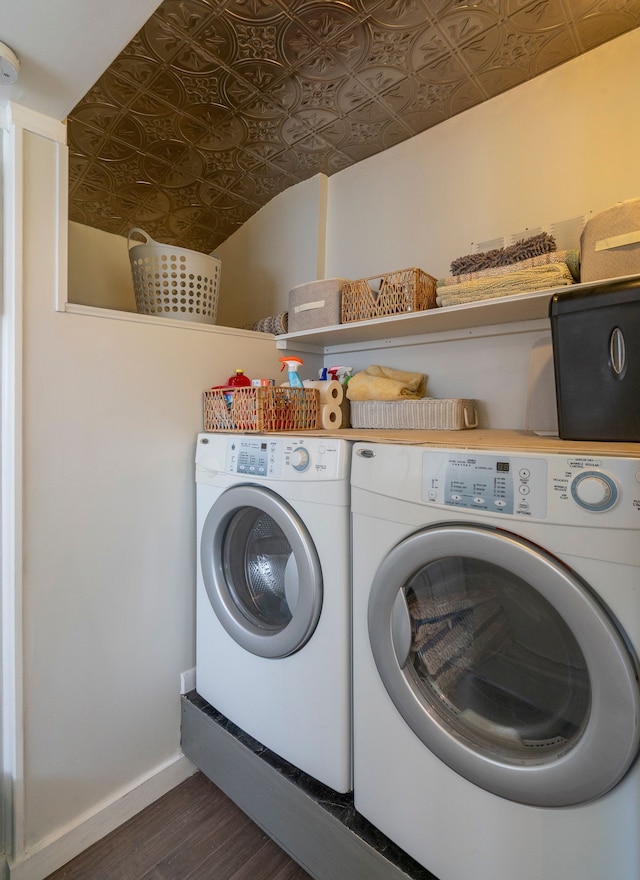 clothes washing area featuring washing machine and dryer, laundry area, dark wood-type flooring, baseboards, and an ornate ceiling