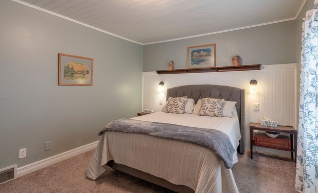 carpeted bedroom with ornamental molding, visible vents, and baseboards