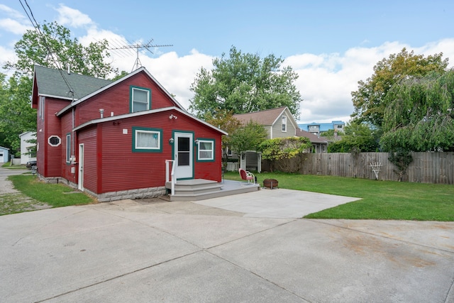 rear view of property with a patio area, fence, and a yard