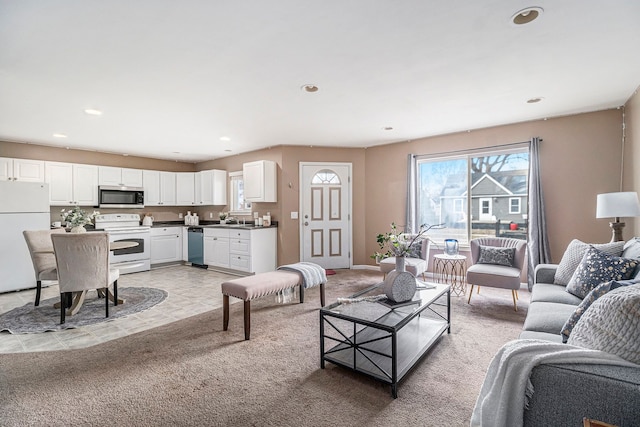 living room featuring light carpet, baseboards, and recessed lighting