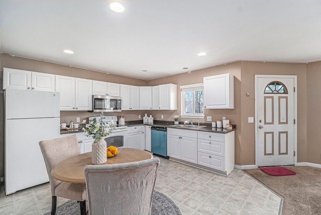 kitchen with recessed lighting, white appliances, a sink, baseboards, and white cabinets