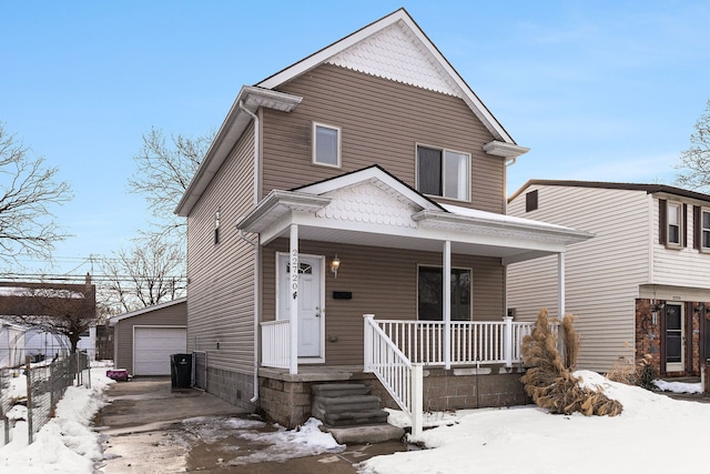 view of front facade with covered porch, a detached garage, and an outbuilding