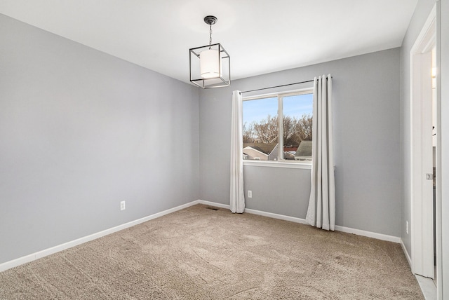 empty room featuring carpet floors and baseboards