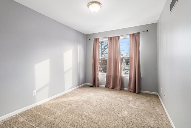 spare room with baseboards, visible vents, and carpet flooring