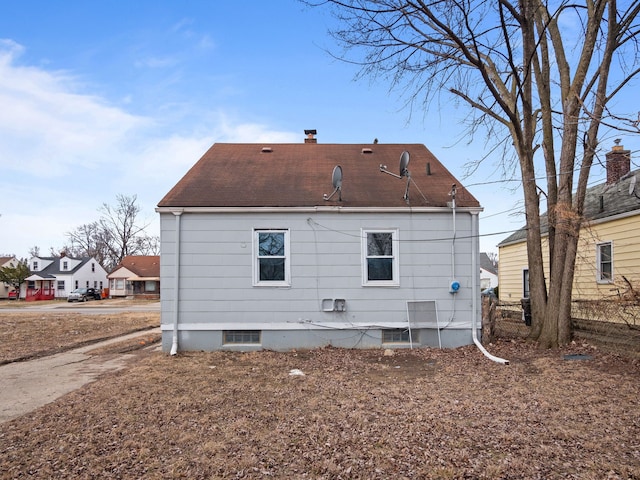 back of house with a chimney