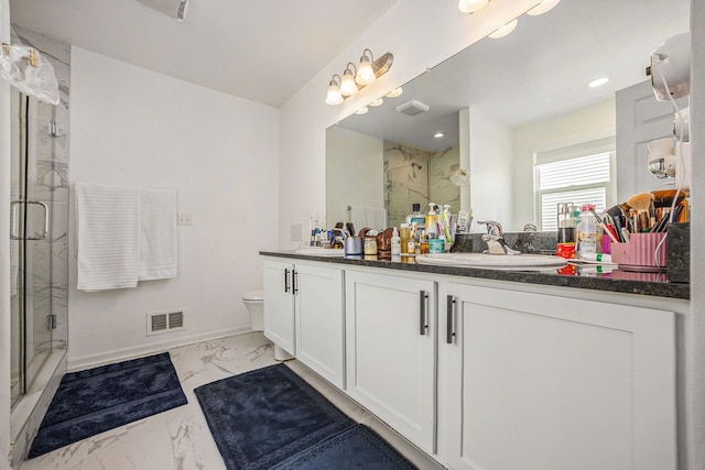 bathroom with marble finish floor, double vanity, a stall shower, and a sink