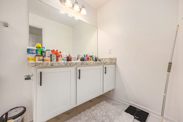 bathroom featuring marble finish floor, baseboards, and vanity