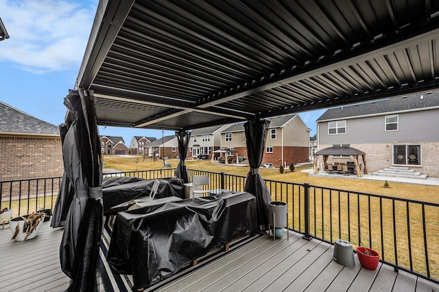 wooden terrace with a residential view, a pergola, and a yard