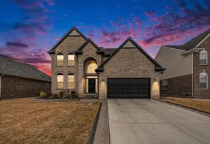 french country style house with concrete driveway and an attached garage