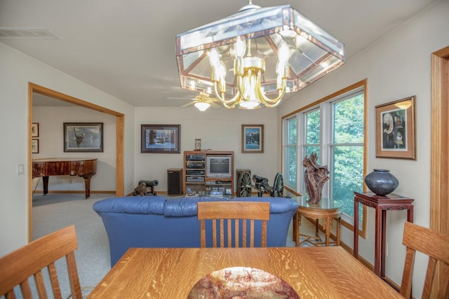 dining room with a chandelier, carpet, visible vents, and baseboards