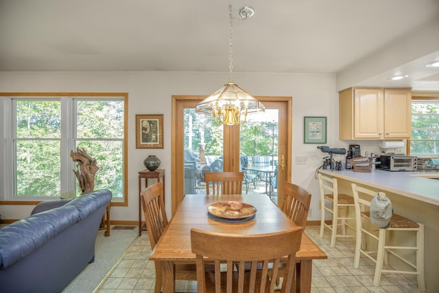 dining area with baseboards, plenty of natural light, light tile patterned flooring, and a notable chandelier